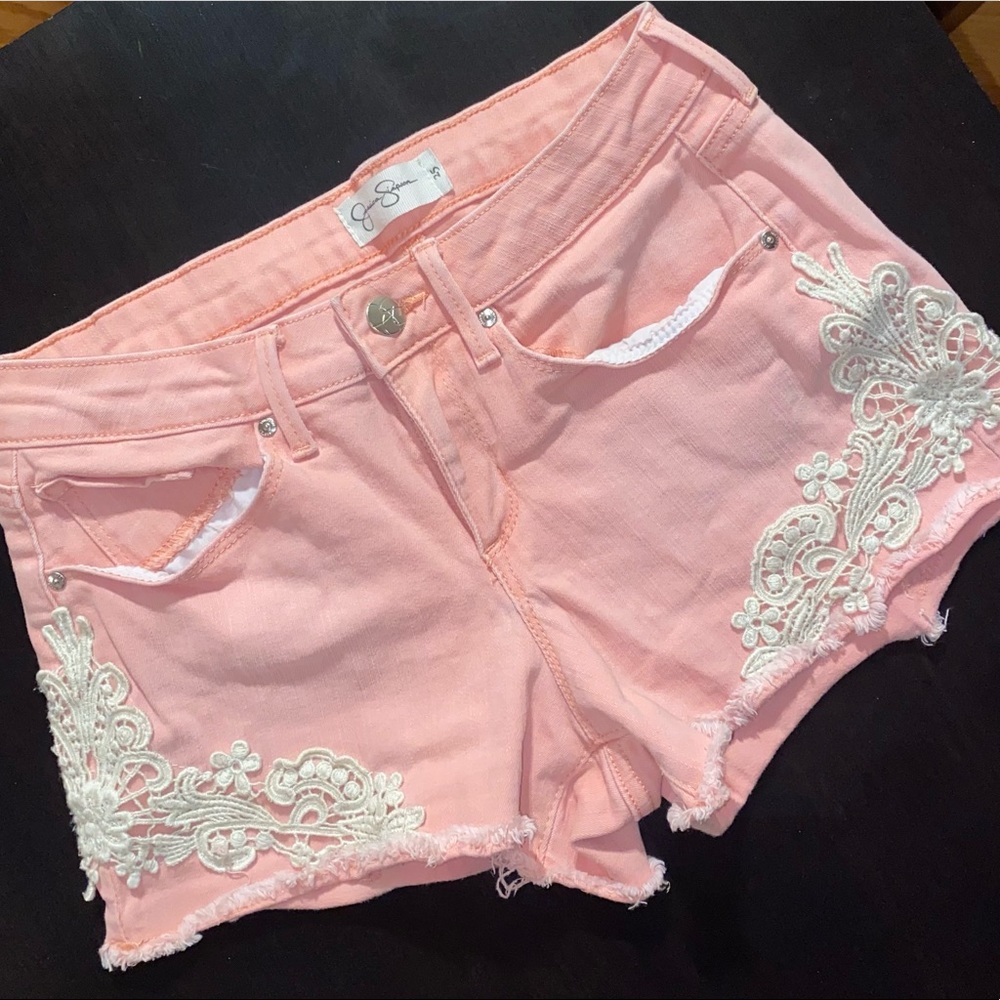 Light pink distressed jean shorts with design